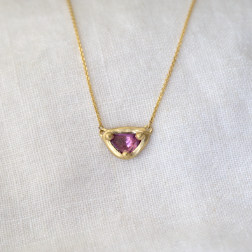 A beautiful rose cut pink sapphire prong set in luxurious 18k gold, that is carved to perfectly mirror the irregular shape of the stone.