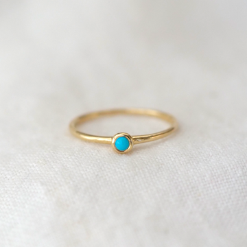 turquoise cabochon bezel set in 14k gold on a simple 14k gold band 