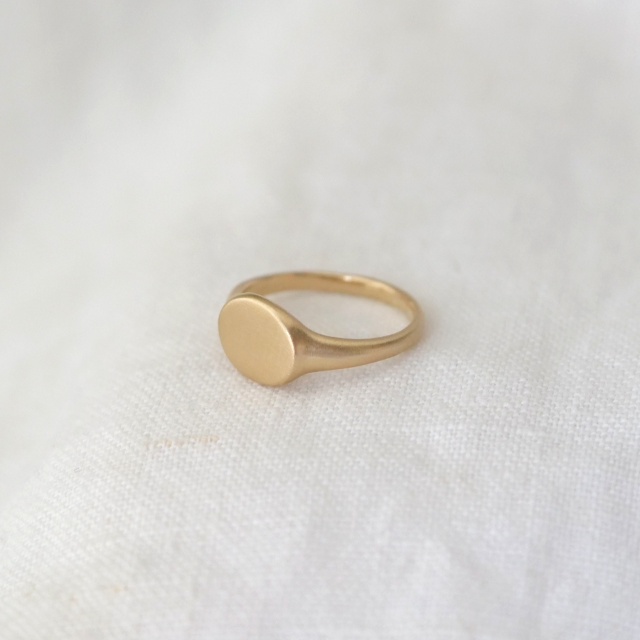 signet ring made of solid 14k gold with an oval face and matte finish