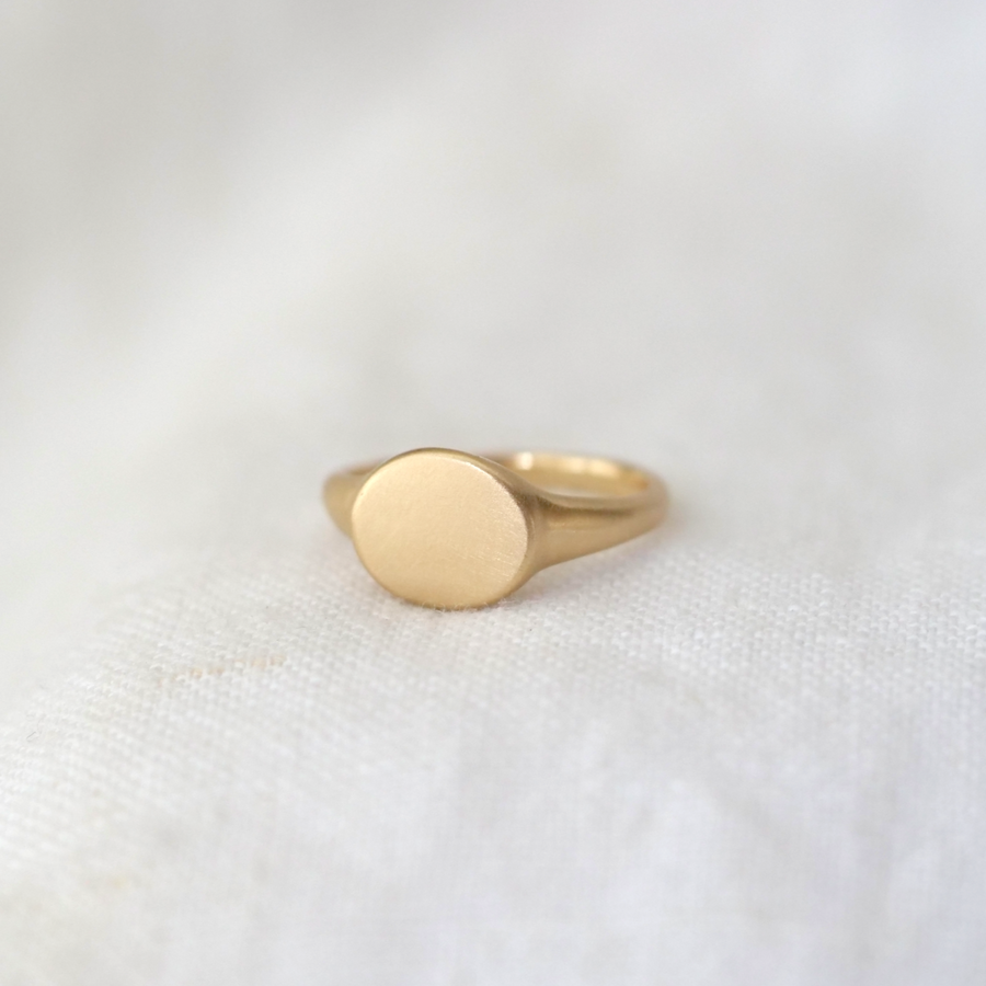 signet ring made of solid 14k gold with an oval face and matte finish