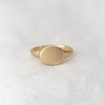 signet ring made of solid 14k gold with an oval face and matte finish