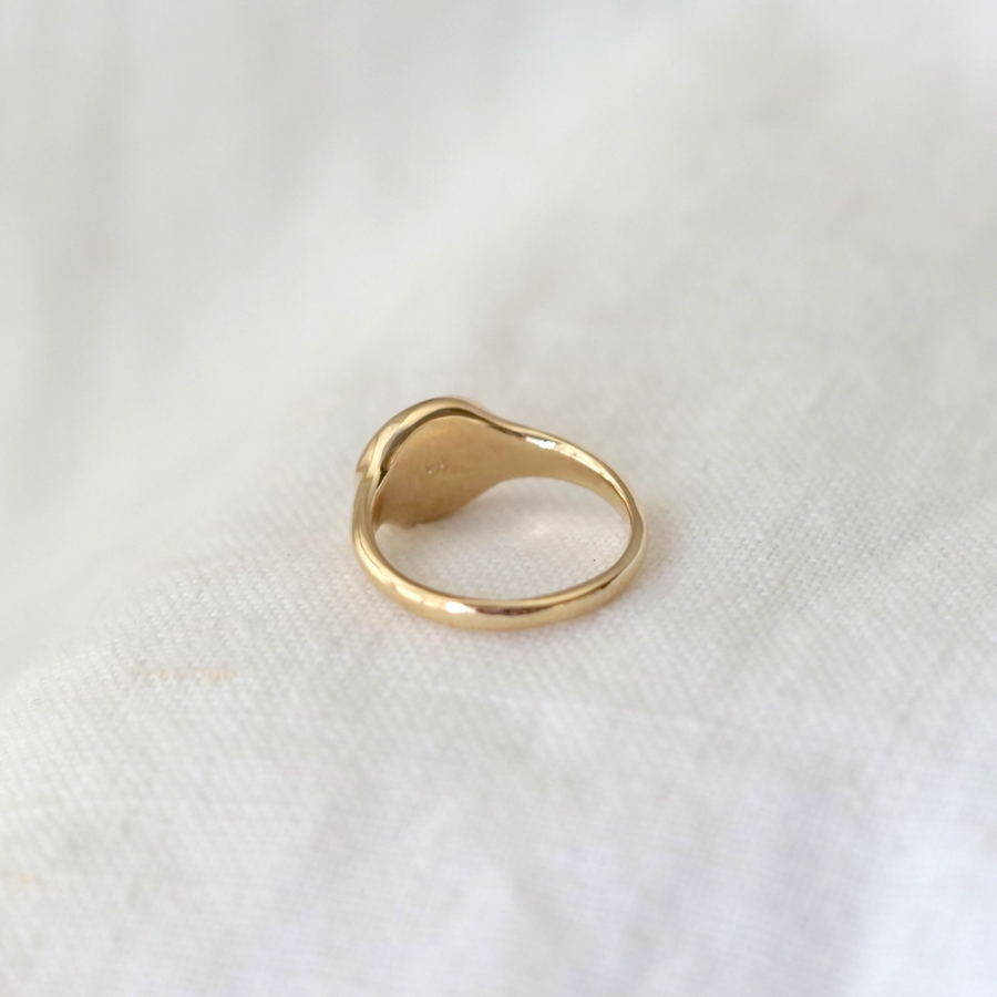 signet ring made of solid 14k gold with an oval face and high polish finish