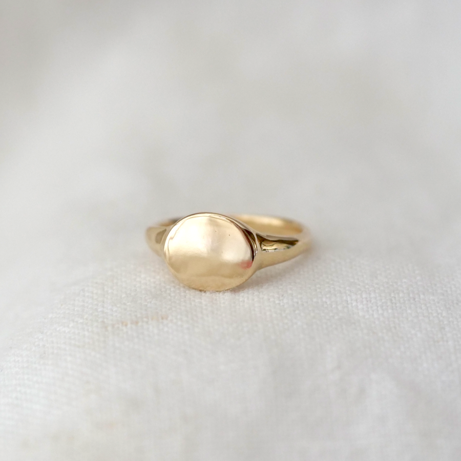 signet ring made of solid 14k gold with an oval face and high polish finish