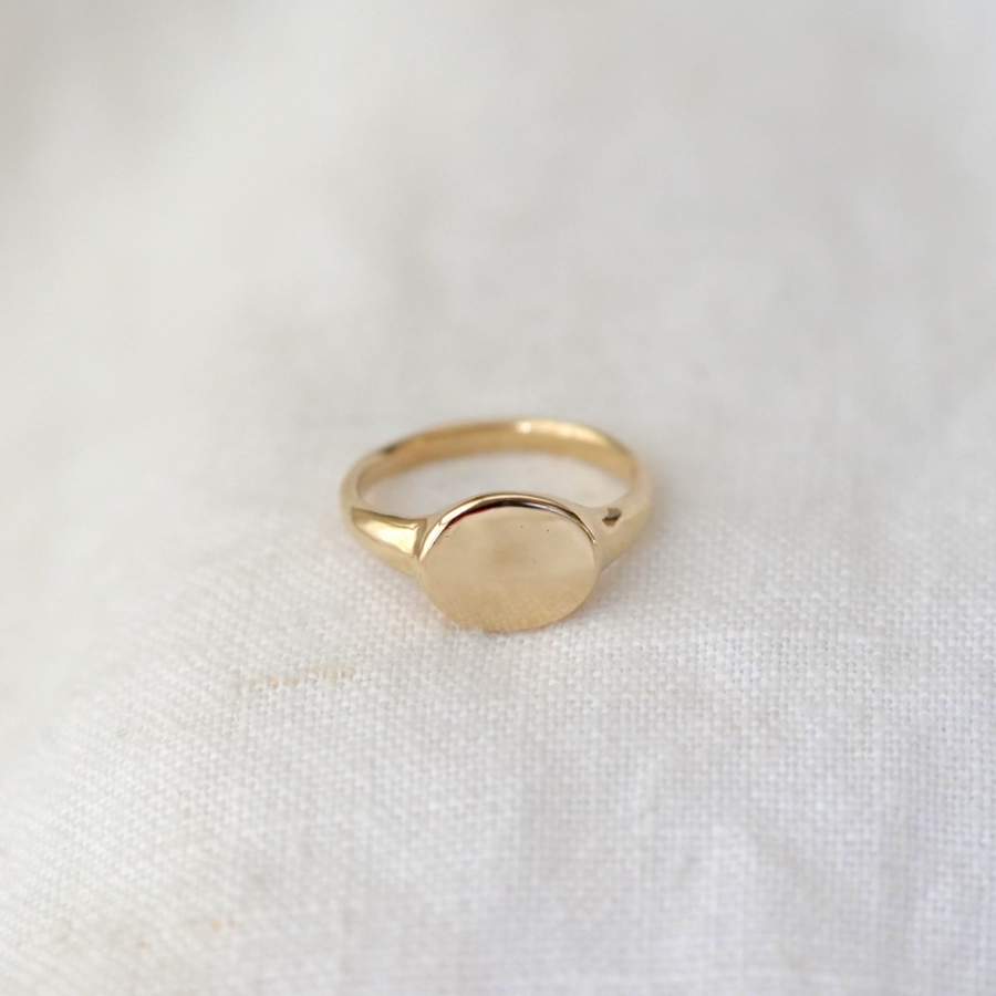 signet ring made of solid 14k gold with an oval face and high polish finish