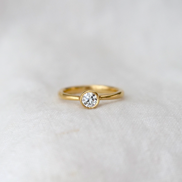 solitaire diamond bezel set in 18k gold on a tapped 18k band 