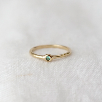 Brilliant cut emerald flush set in a 14k gold band