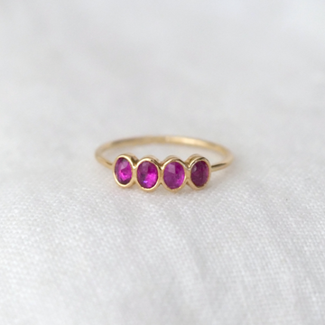 four oval rubies bezel set in a row in 14k gold on a thin 14k gold band