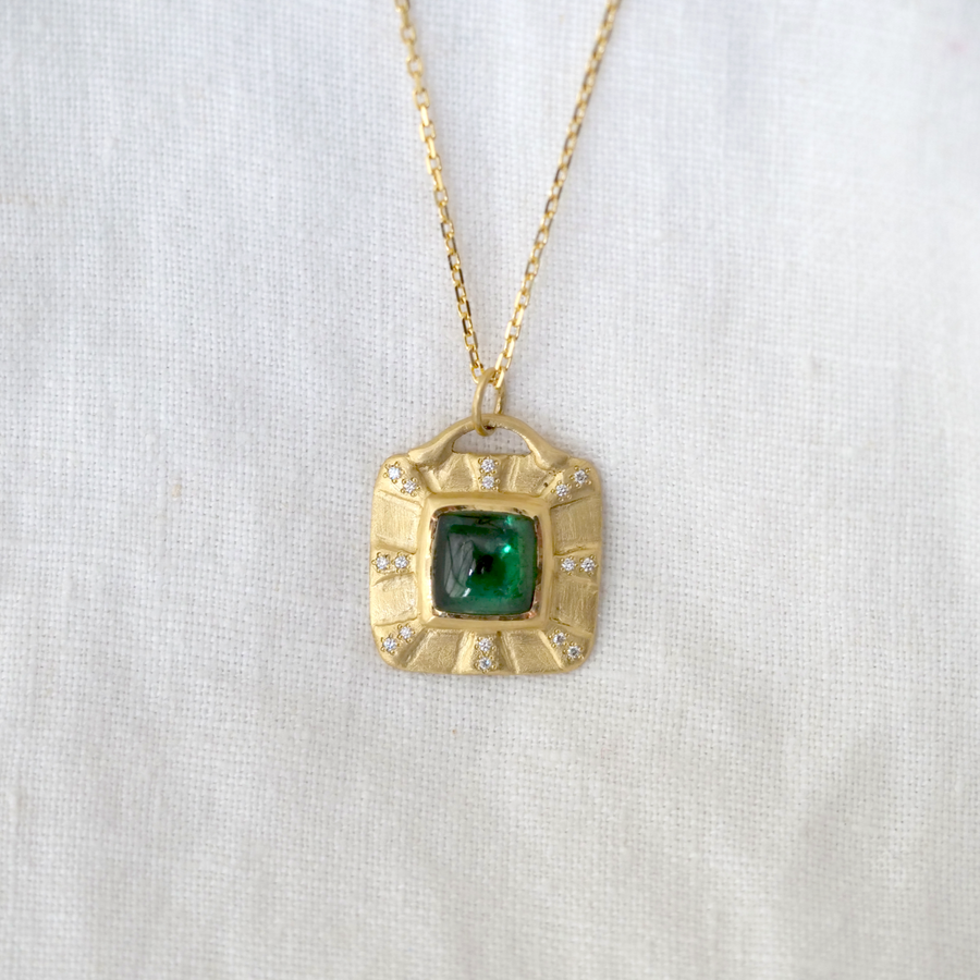 This unique one of a kind piece features a square cabochon cut Tourmaline set in 18KY gold with a dusting of pave diamonds