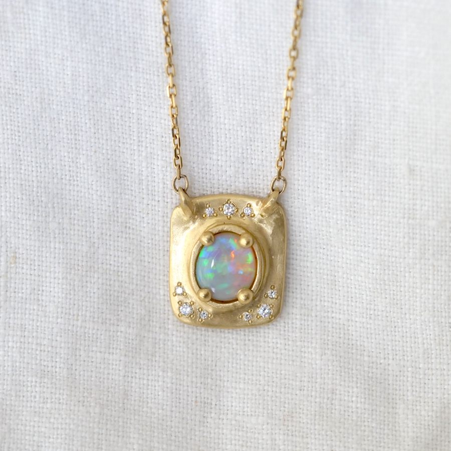 Australian crystal opal has a beautiful play of color and changes with the change of light reflecting from it. The 18K gold setting hosts a lovely dusting of pave white diamonds.  