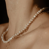 2 of 2: Large white pearls stung on a short strand, on a model 