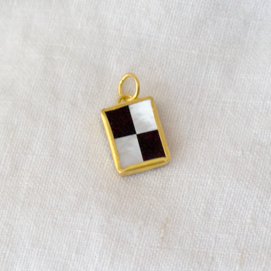 Black Onyx & Mother of Pearl set as a checker board in 24k gold bezel setting and bale, with a sterling silver back