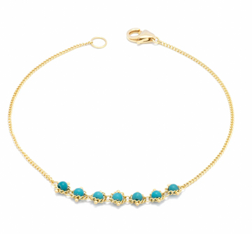 Two swaths of 18K yellow gold chain lead to this jewel’s striking centerpiece: a row of seven Turquoise beads, each sky blue gemstone precisely hand-woven into a web of delicate yellow gold chain.