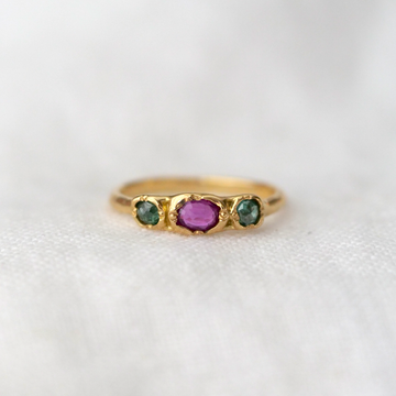 An unusual but stunning color combination, this ring has one purply/ pink ruby, with two greenish blue diamonds on either side