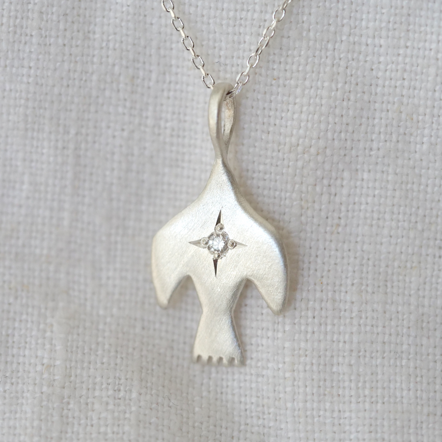 sterling silver bird pendant with a single white diamond star set in the center 