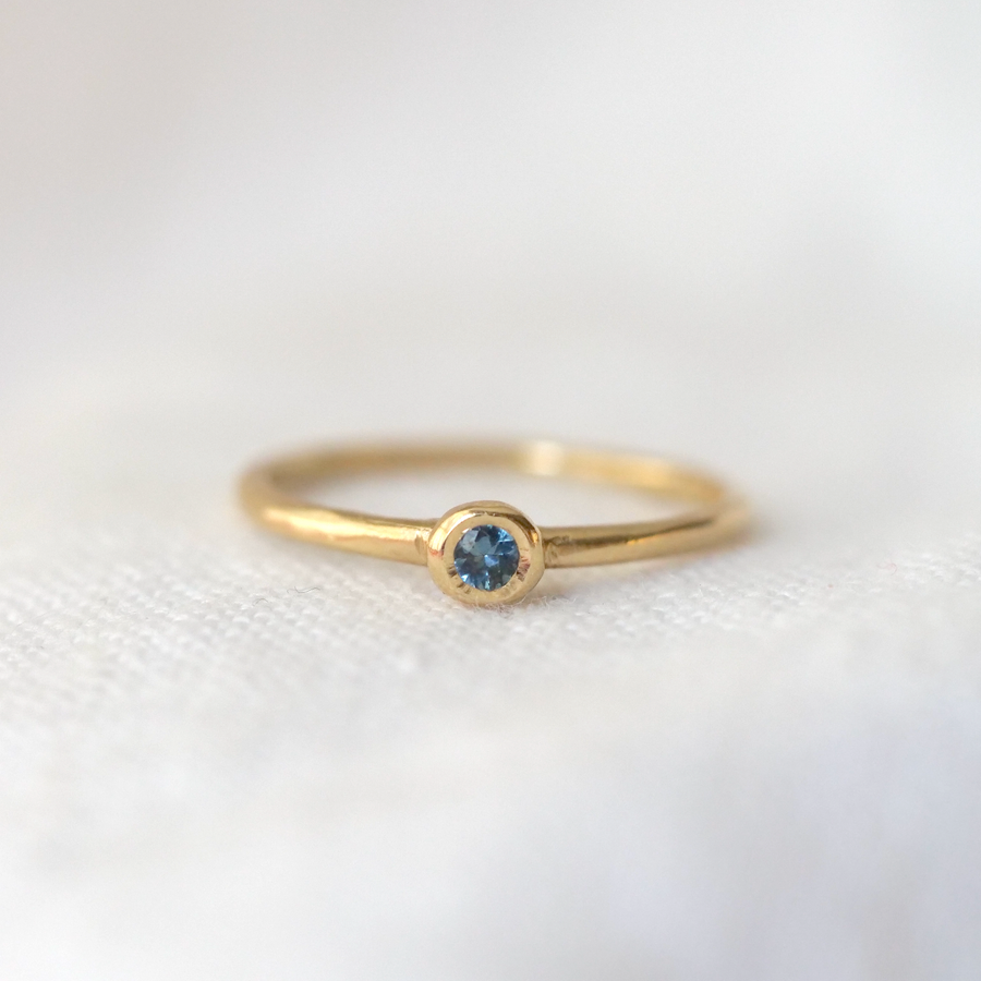 faceted blue Montana Sapphire stone bezel set in 14k gold on a thin band