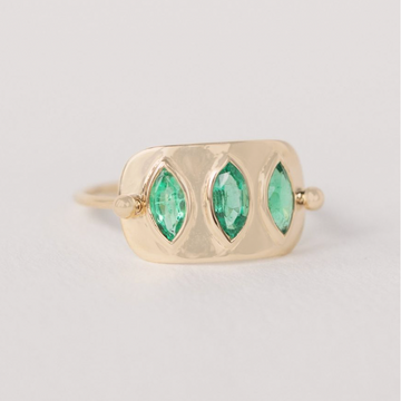 Gold plate with three green marquise cut emeralds set 