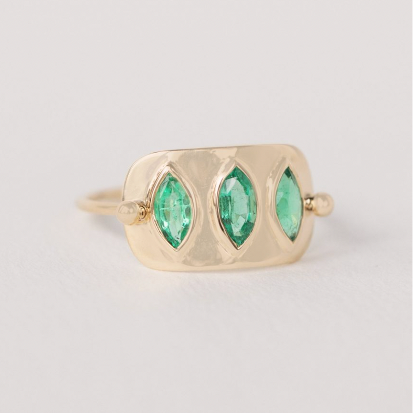 Gold plate with three green marquise cut emeralds set 