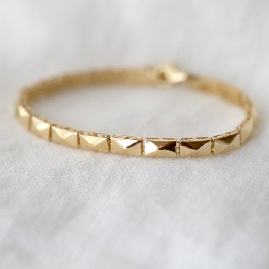 14k gold bracelet made up of rectangular solid links with a four facets 