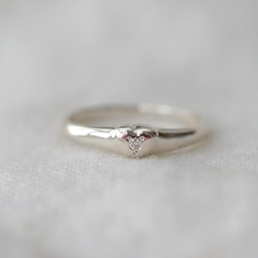 A sweet hand carved heart signet in sterling silver with a stone in the center