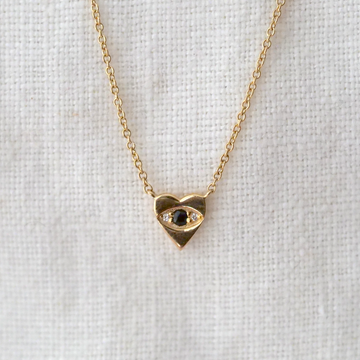 Solid 14k yellow gold heart with bead set black diamond and white diamonds on either side.