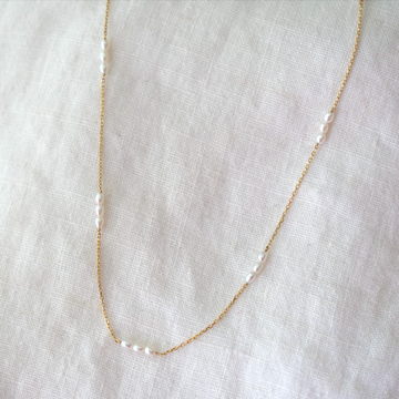 14k shimmery chain with seven groups of three pearls evenly strung along it