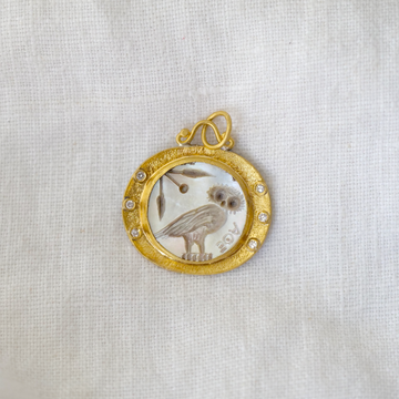 owl carved into mother of pearl, framed in an oval form of rich 24k gold, 3 white diamonds set to either side