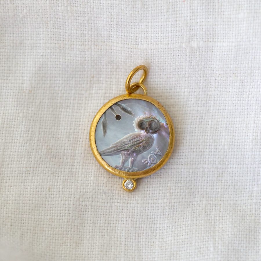 mother of pearl pendant, with a carved Intaglio image of an owl framed with 22 kt gold and a diamond