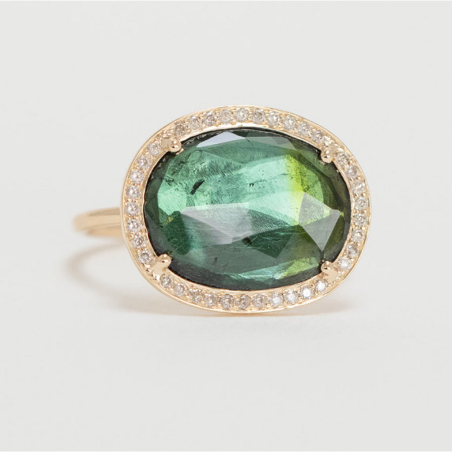 14k light yellow gold ring with a bezel set green tourmaline surrounded by diamonds