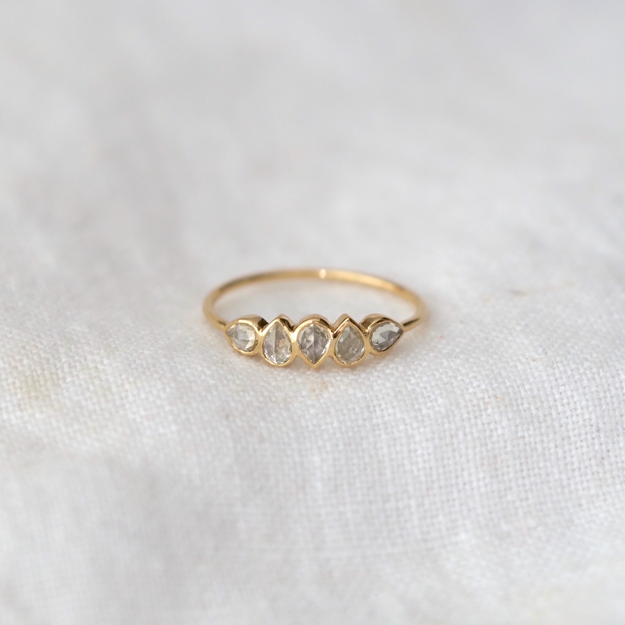 Five small rose-cut white sapphires of varying shapes, set in 14k yellow gold