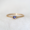 Lightweight 14k gold band with a beautiful pear cut gemstone bezel set in the center