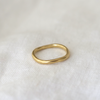 handcrafted 2.5mm solid gold band, showcasing a natural texture and wavy profile