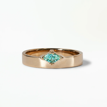Gold ring with a green marquise gemstone on a white background