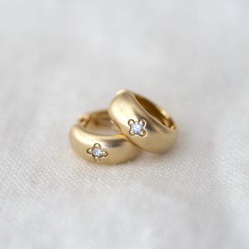 This image features a pair of elegant single star hooped earrings, crafted in a lustrous gold. Each earring is designed with a simple yet captivating star detail, subtly enhancing their charm and appeal.