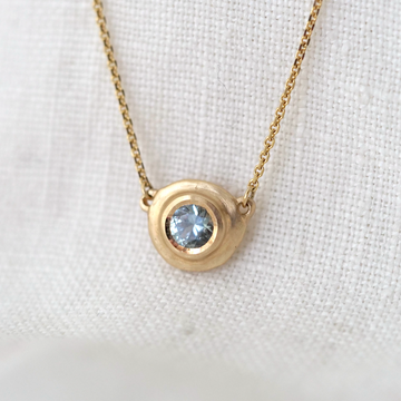 light blue Montana Sapphire brilliant cut stone set in an organically sculpted bezel setting