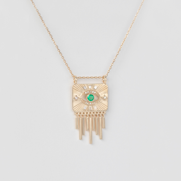 gold plate necklace with gold dangles and emerald on white backdrop