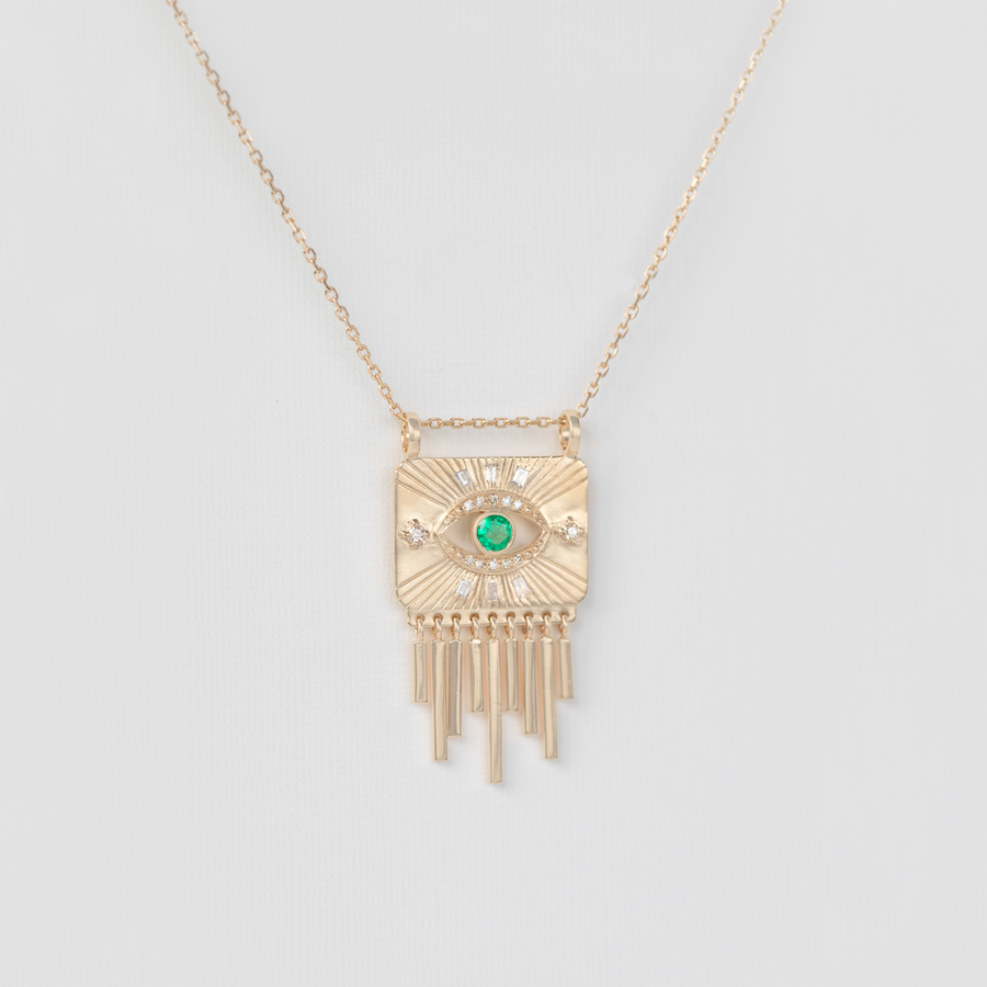 gold plate necklace with gold dangles and emerald on white backdrop