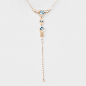 gold and aquamarine dangling lariat necklace on white backdrop