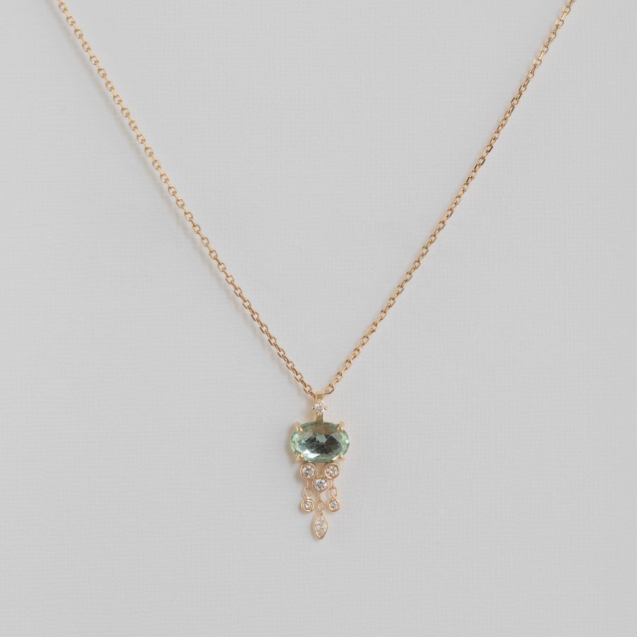 light green stone and diamonds in 14k yellow gold over white backdrop