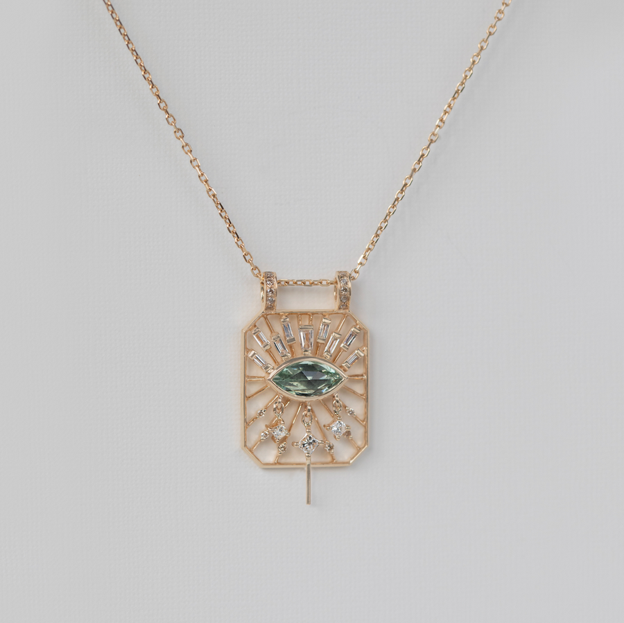 tourmaline 'eye' is surrounded by white diamonds suspended on dainty gold spindles on a cut out dog tag pendant