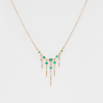 detailed emerald and diamond necklace on white backdrop