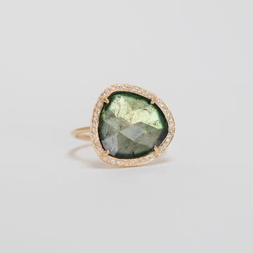 14k yellow gold ring with a unique sage green tourmaline surrounded by diamonds.