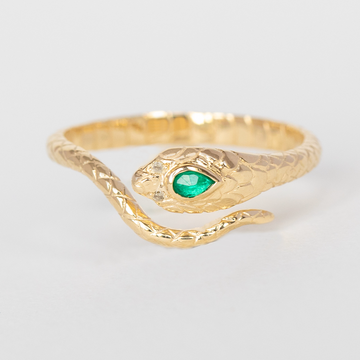 14k light yellow gold cobra ring with one emerald and two diamonds.