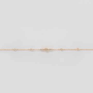 delicate white diamonds set along a 14k gold chain bracelet 