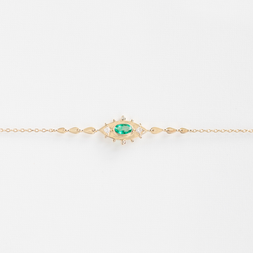 oval emerald set in 14k bracelet with graulation detail and two white diamonds 