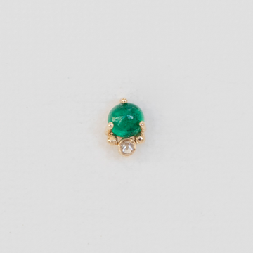 A delicate emerald cabochon set in 14K gold with a little sparkling diamond. 