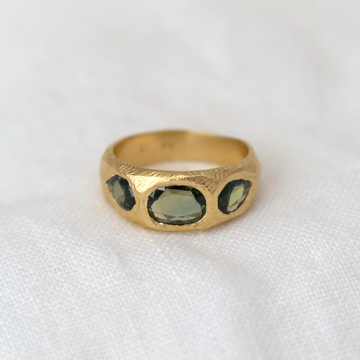 A sculptural 18 karat gold hand carved ring with 3 vibrant freeform rose cut sapphires