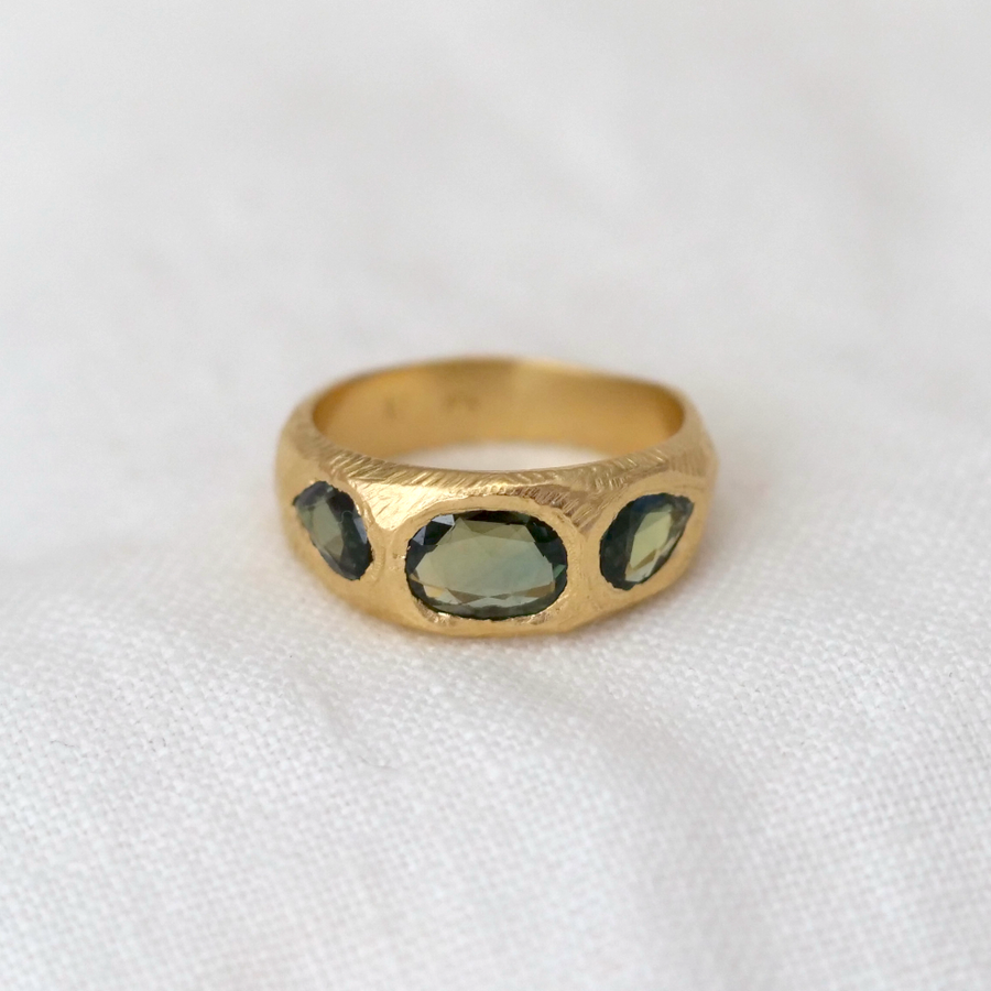 A sculptural 18 karat gold hand carved ring with 3 vibrant freeform rose cut sapphires