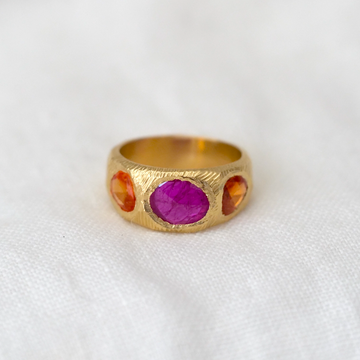 A sculptural 18 karat gold hand carved ring with 3 vibrant freeform rose cut stones