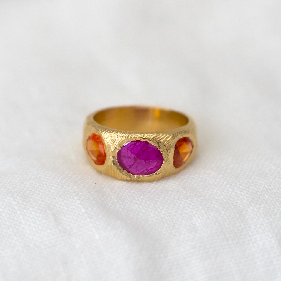 A sculptural 18 karat gold hand carved ring with 3 vibrant freeform rose cut stones