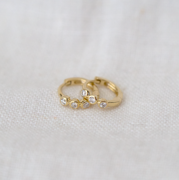 The white diamonds are bezel set in 14K gold in a secure clicker hoop